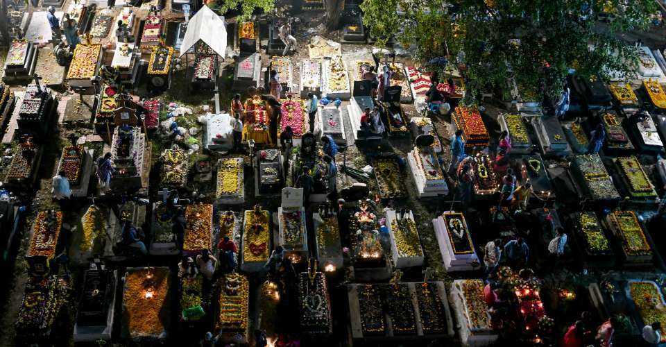 Catholic Christians light candles and decorate the graves of deceased family members as they pay their respects at a cemetery as part of All Souls' Day commemorations in Hyderabad, India, on Nov. 2, 2025.
